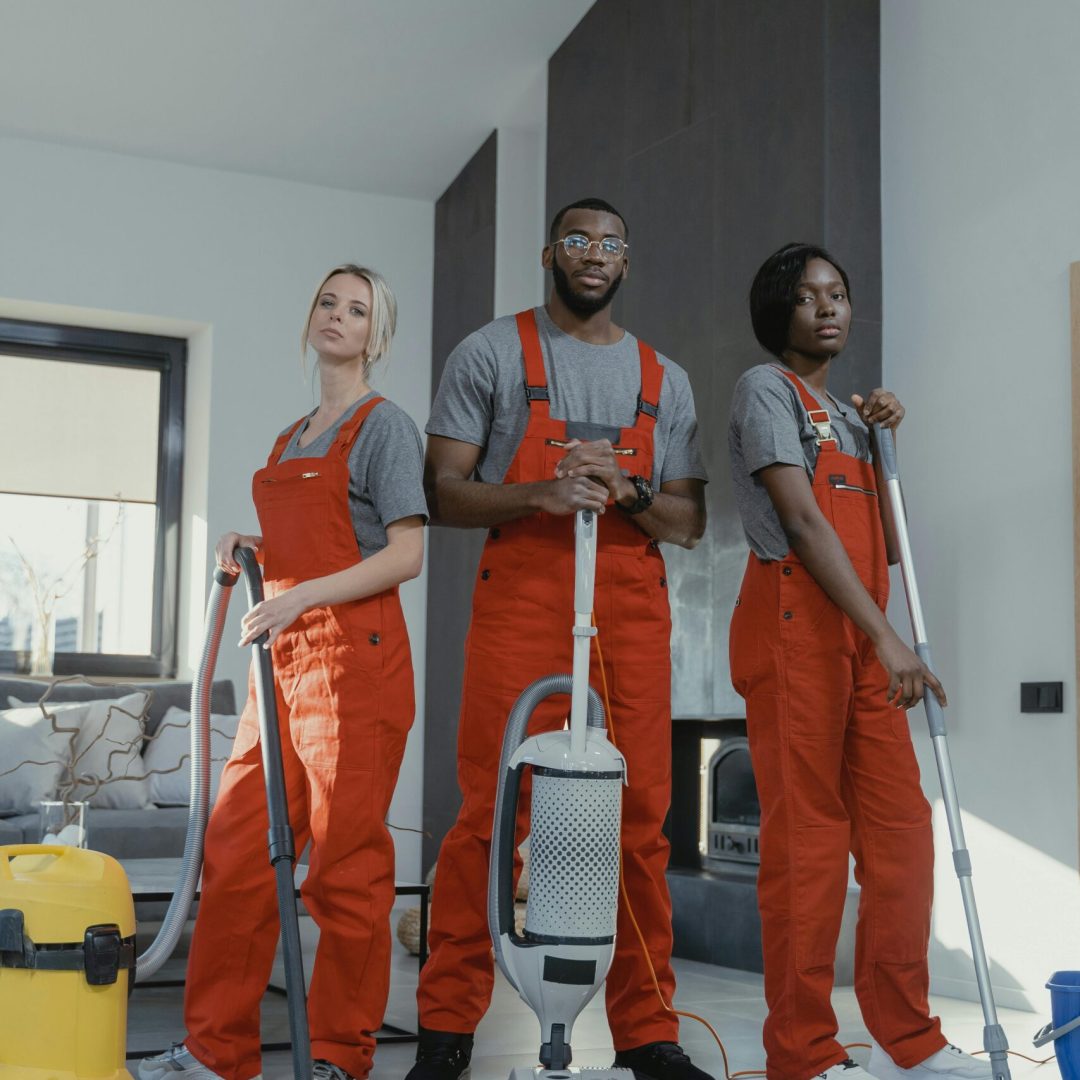 pexels-photo-6195131-6195131 Three cleaners in uniform with equipment in a modern home interior, showcasing teamwork and professionalism.